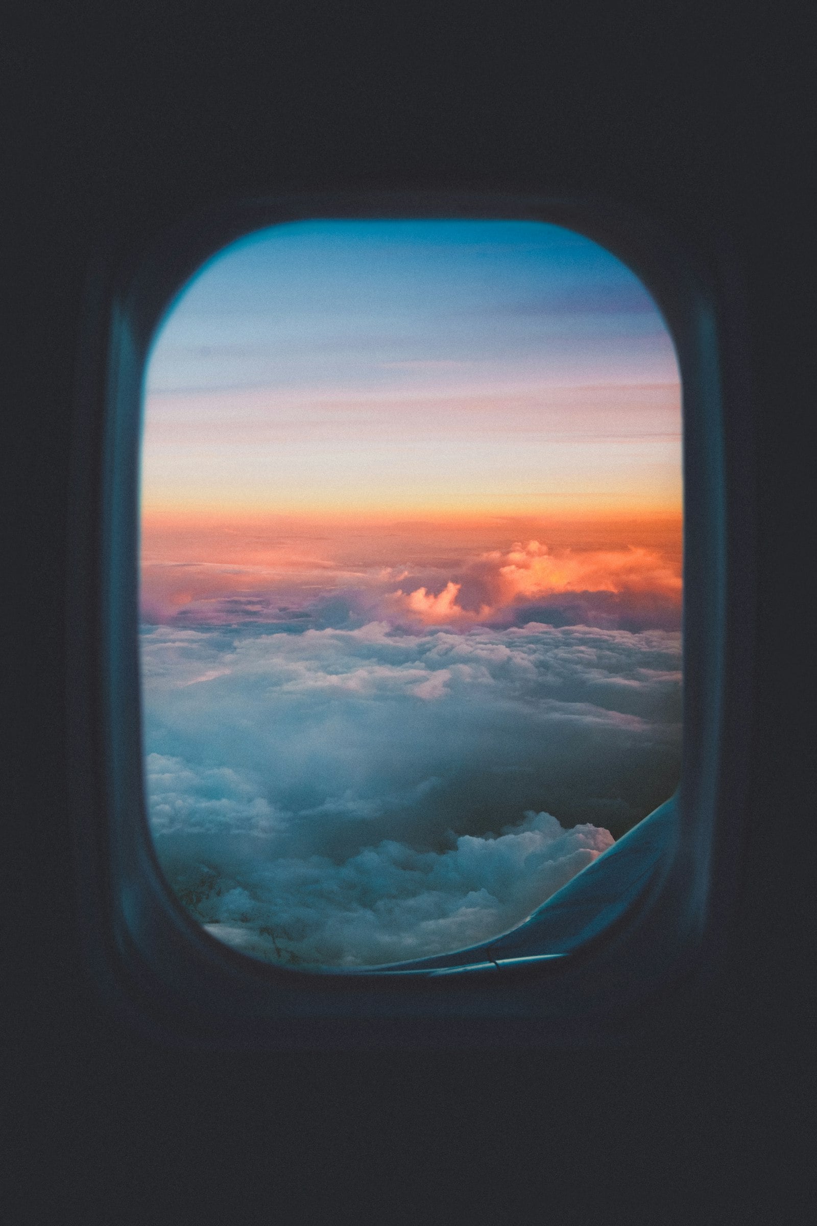 View of sunset clouds through an airplane window (photo: Sasha Freemind / Unsplash)
