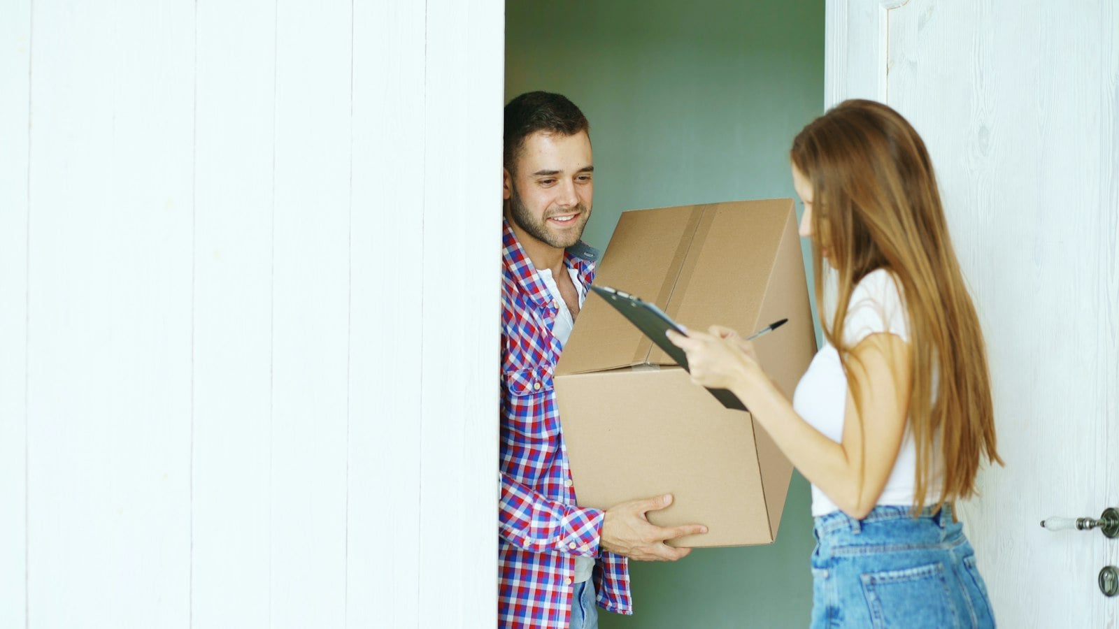 A couple receiving a cardboard delivery box at the door (photo: Vitaly Gariev / Unsplash)