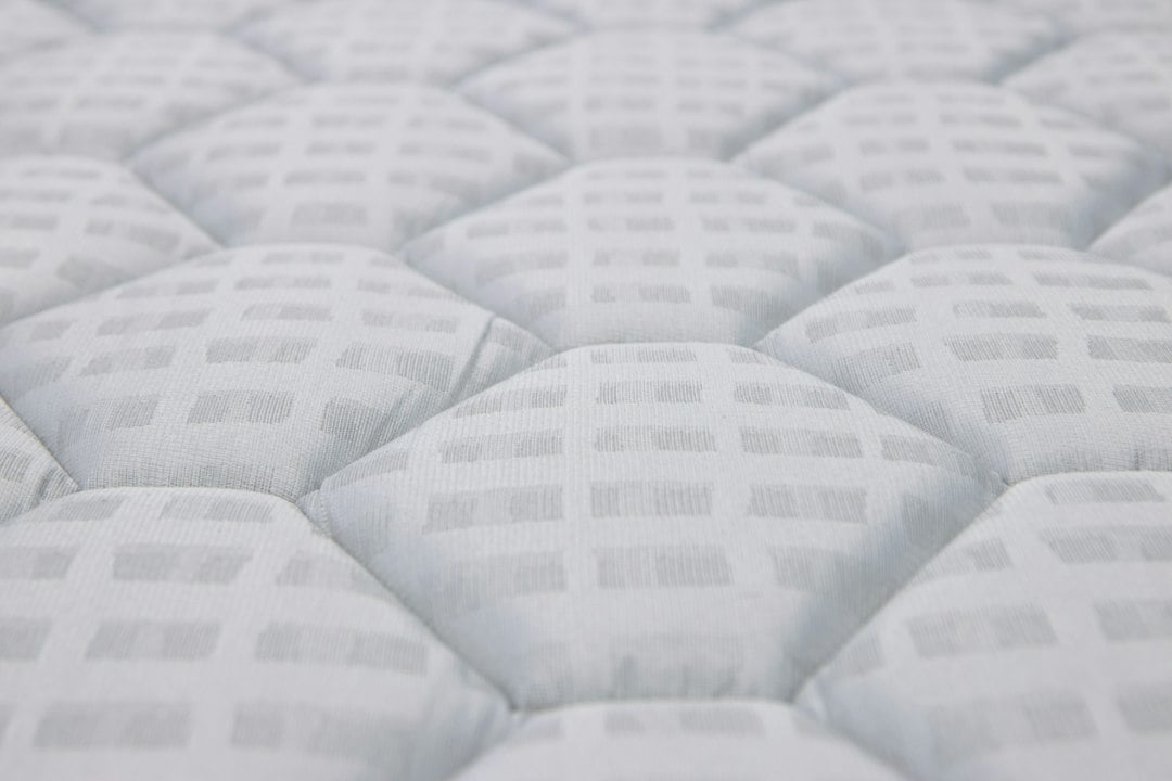 Close-up of the quilted white surface of a mattress top