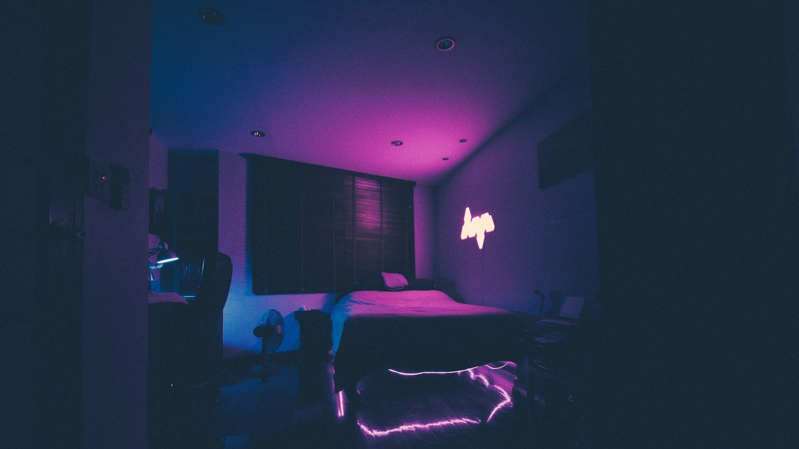 A bedroom lit in purple and pink ambient light (photo: Joshua Rawson-Harris / Unsplash)