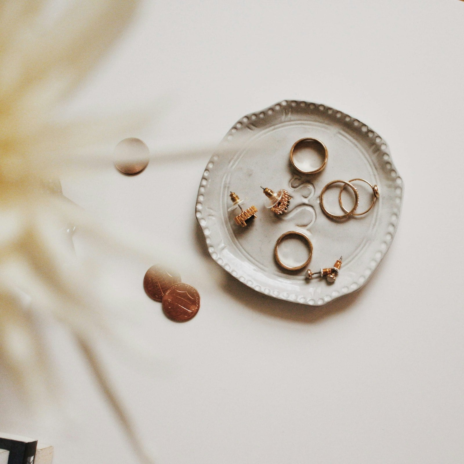 Handmade rings and earrings on a small ceramic dish (photo: Tessa Edmiston / Unsplash)