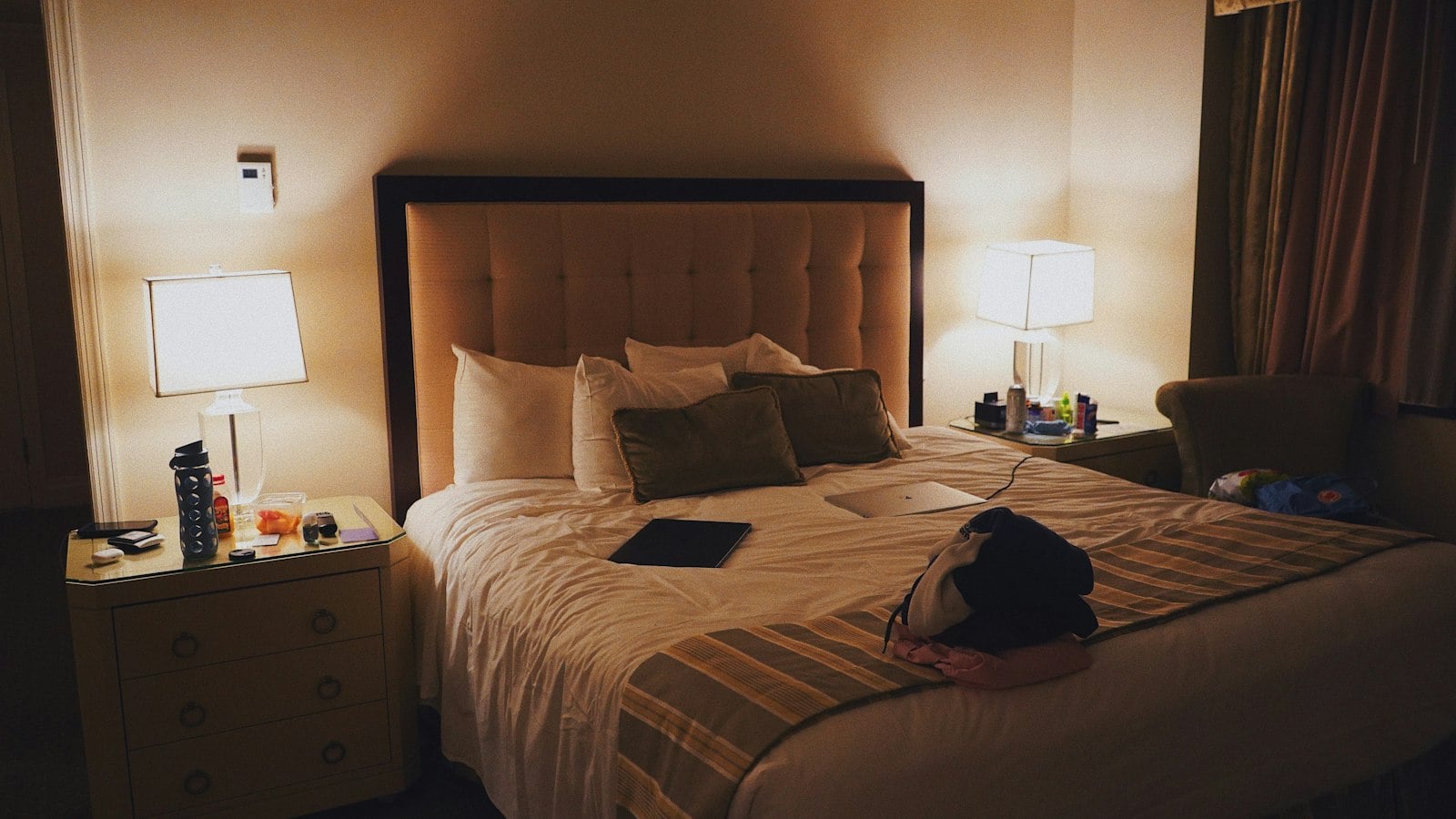 Hotel room with a double bed and bedside lamps (photo: aiden patrissi / Unsplash)