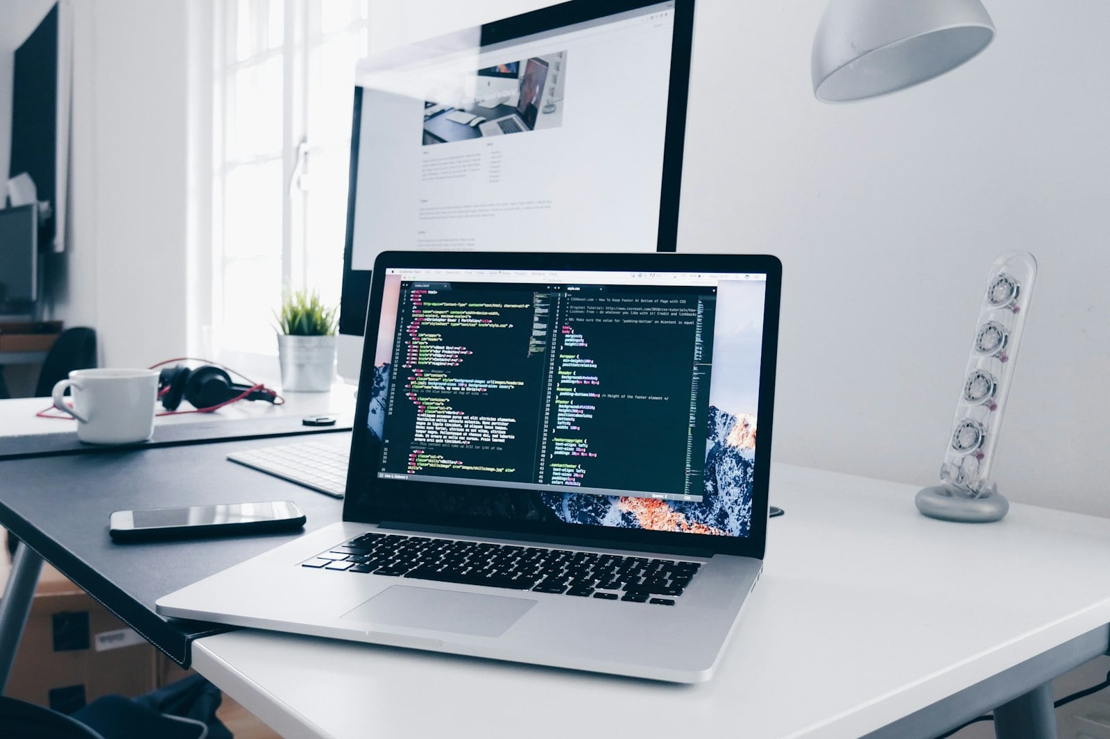 Laptop showing code on a bright home-office desk (photo: Christopher Gower / Unsplash)