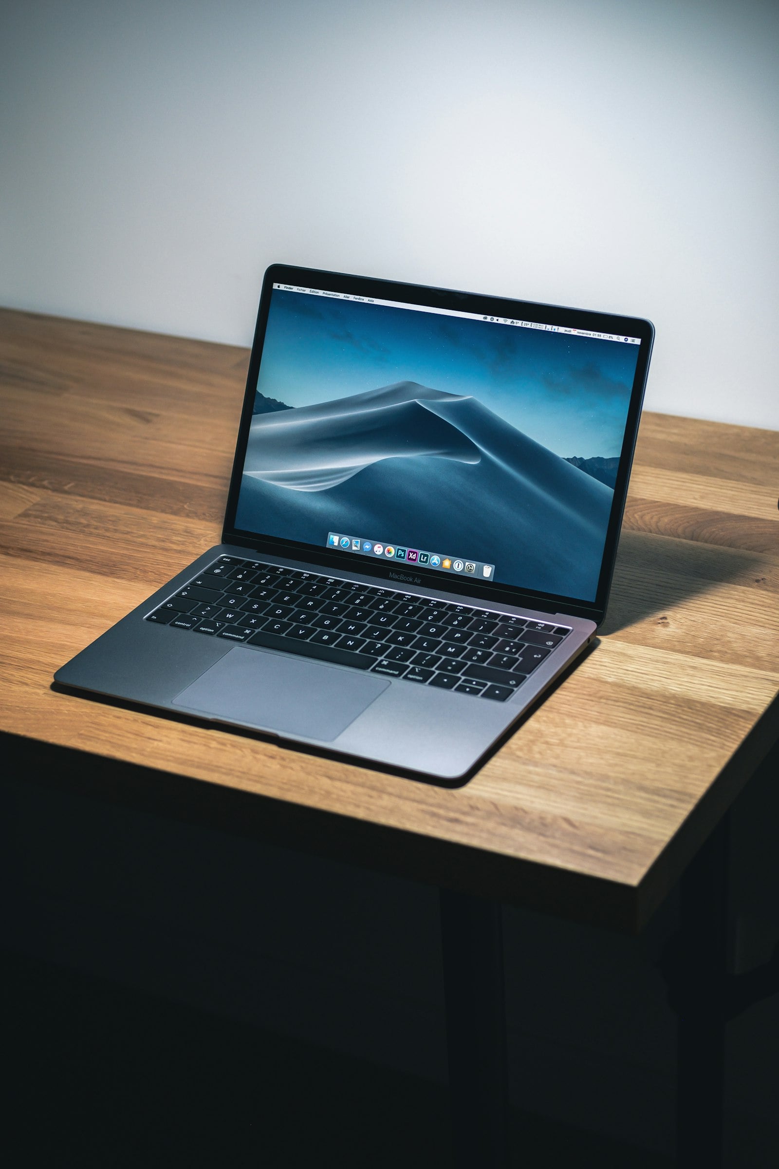 Laptop on a wooden table seen from the side (photo: Howard Bouchevereau / Unsplash)