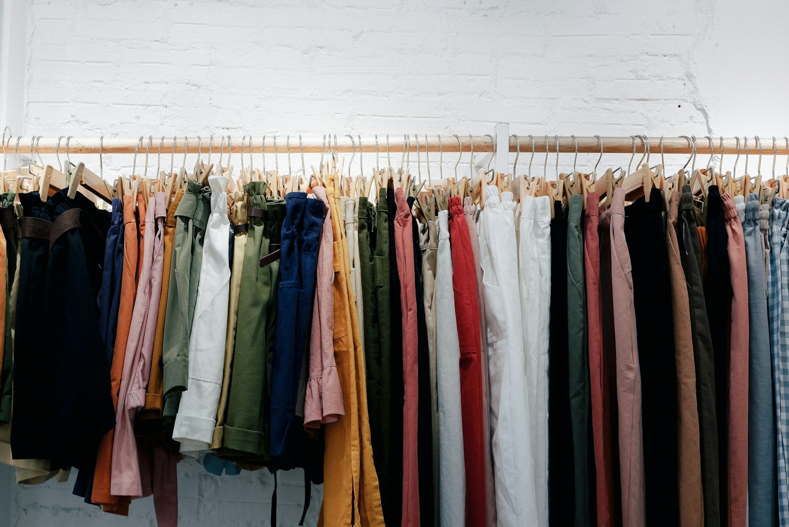 Long clothing rack of colorful shirts and jackets (photo: Fujiphilm / Unsplash)